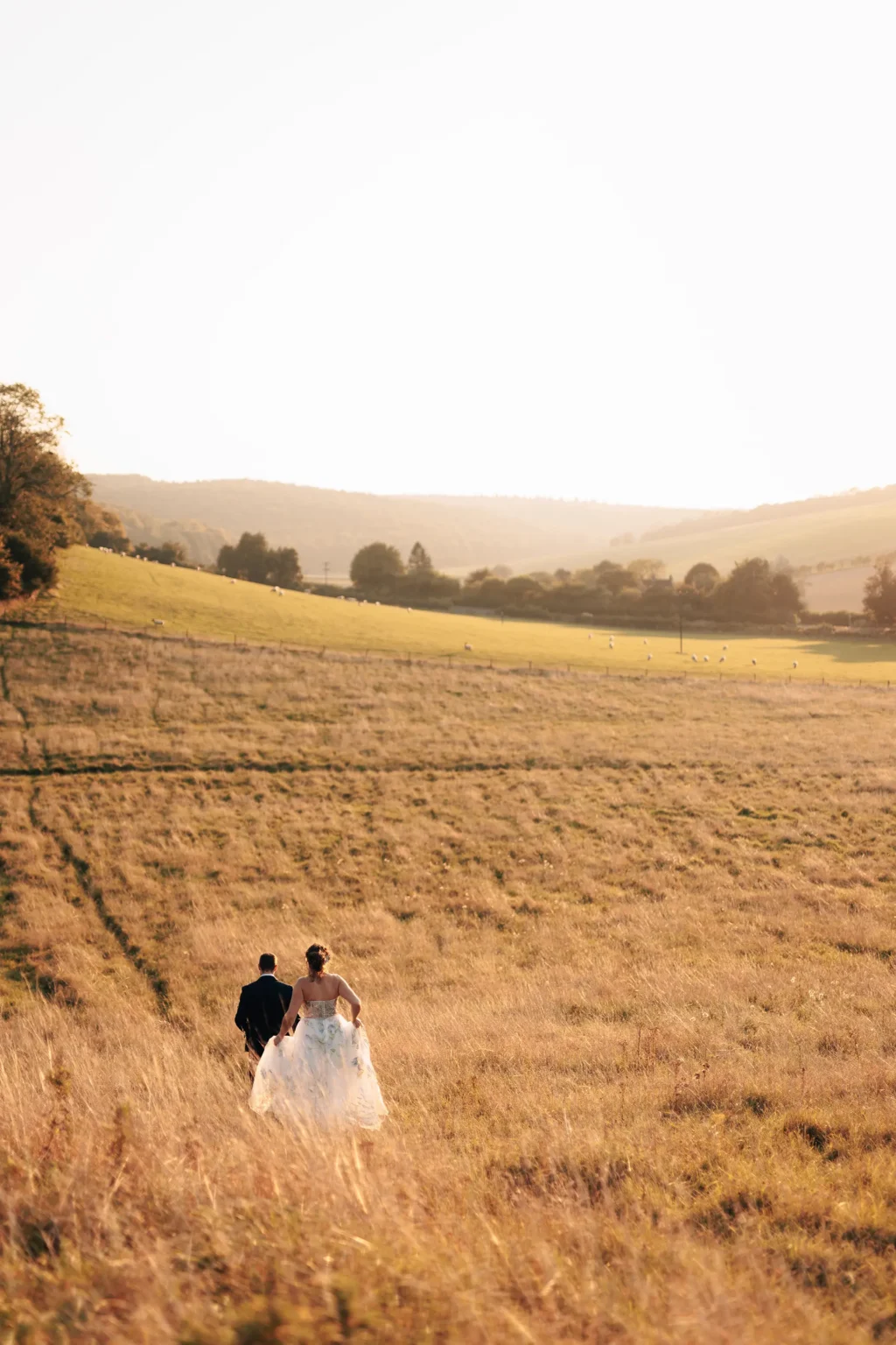 Upwaltham Barns wild weddings couple running through field