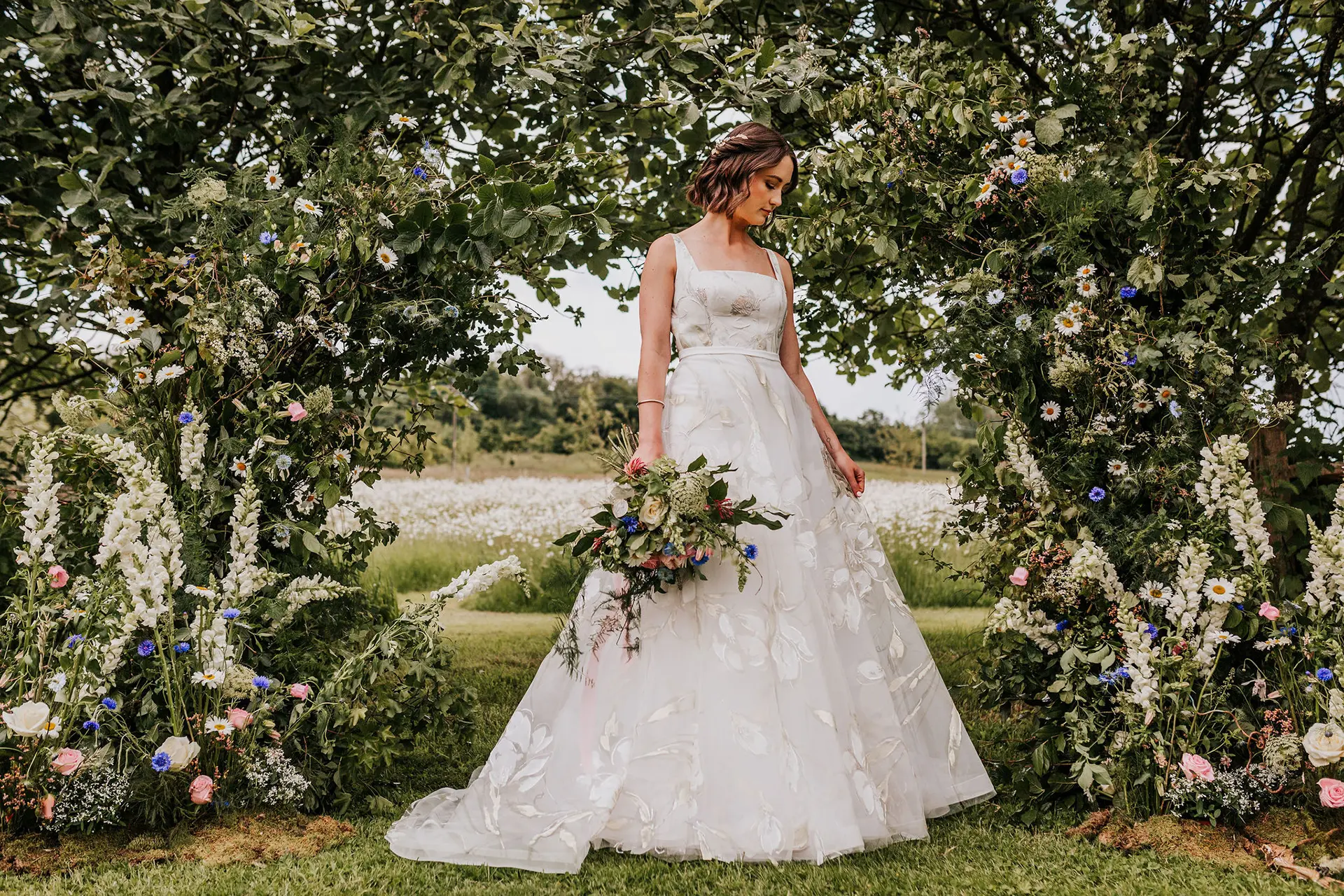 Upwaltham Barns bride amongst wild flowers