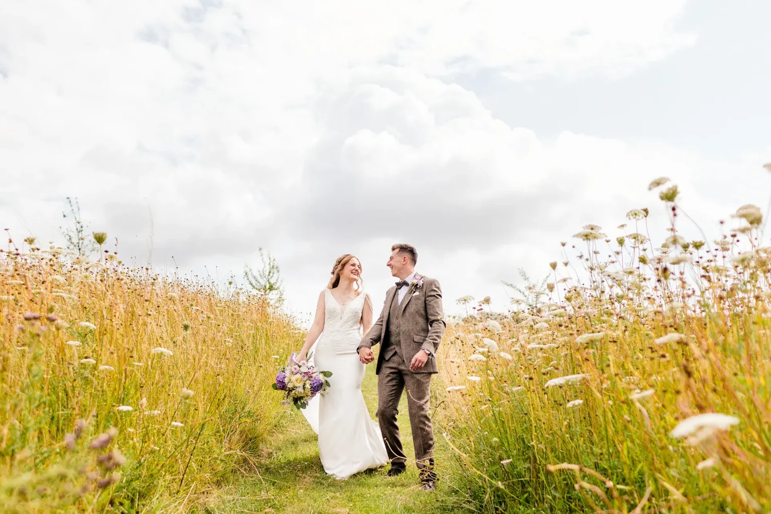 Upwaltham Barns couple walking through wildflower field